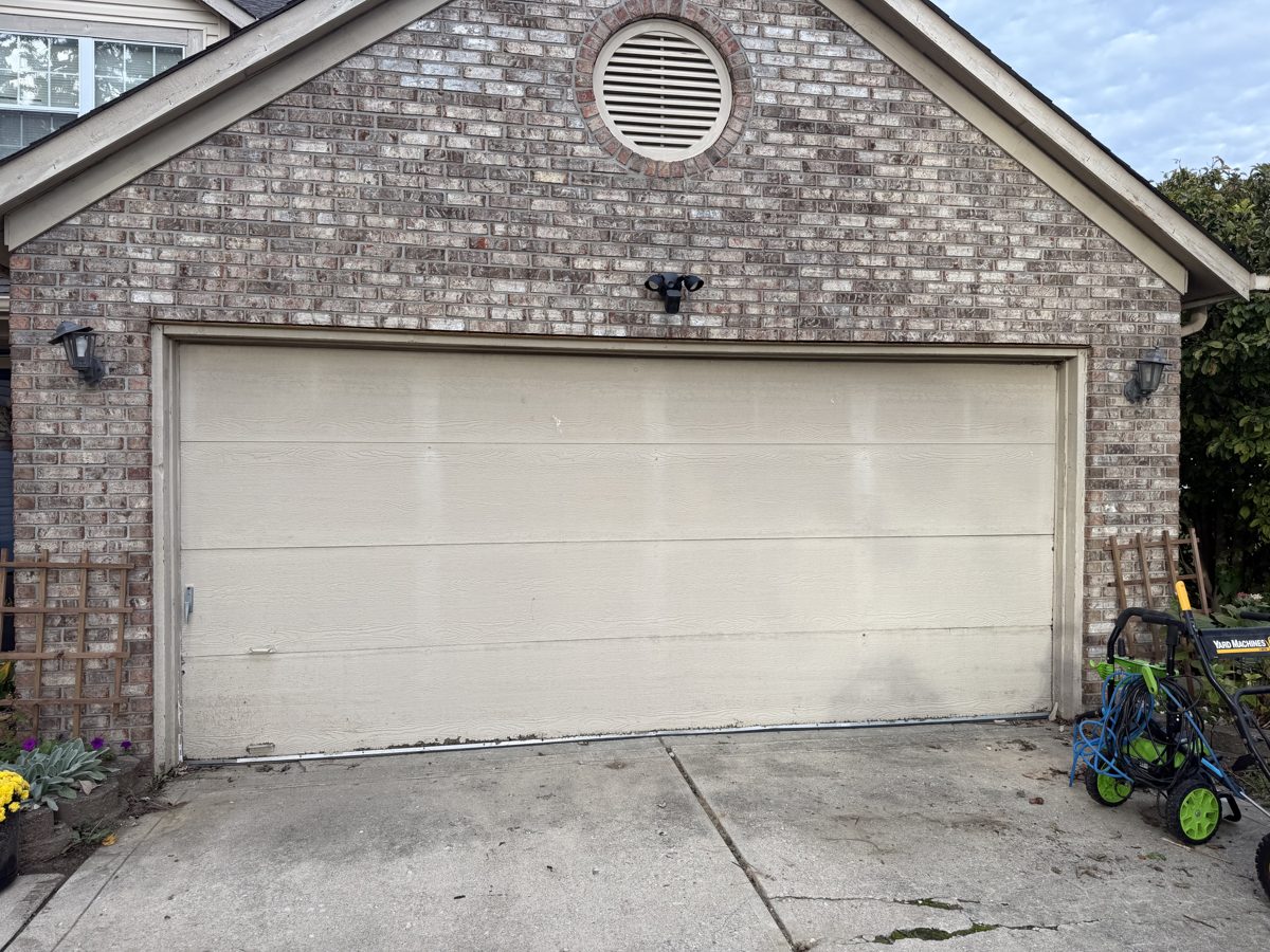 Old flat panel garage door on a brick home in Avon before replacement