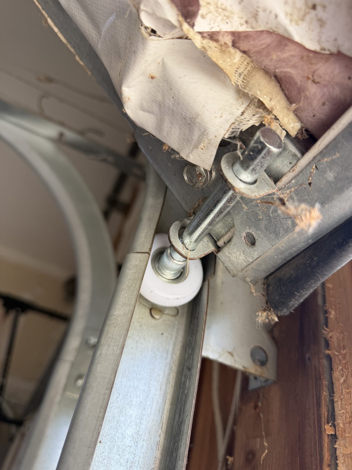 New white nylon garage door roller installed in the track