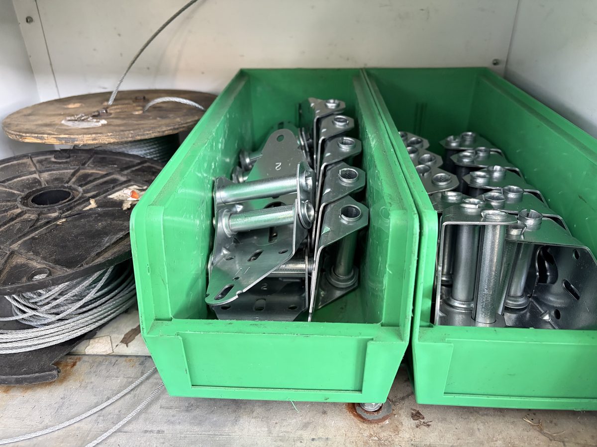Bins of standard replacement garage door hinges stocked on the truck